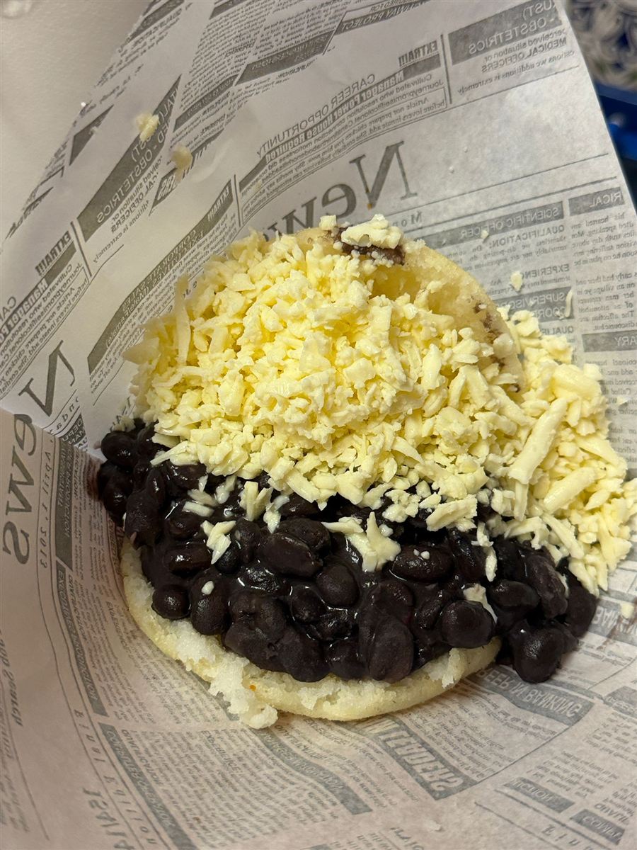 Arepa dominó con caraotas negras y queso blanco rallado